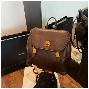 Vintage dunkelbrauner Lederrucksack mit goldenem Drehverschluss und Griff in Lifestyle-Umgebung
