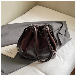 Détail du sac seau marron foncé avec cordon de serrage et textures mixtes en daim