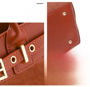 Detail of caramel leather tote showing precise stitching and gold metal buckles