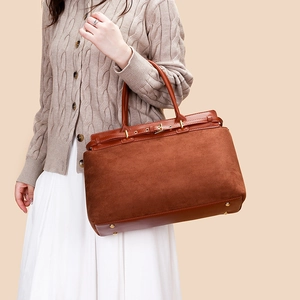 Detail showing the brown suede and smooth leather textures of the large tote bag