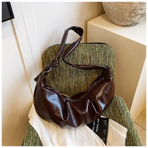 Detail shot of vintage dark brown pleated dumpling bag with knotted shoulder strap design