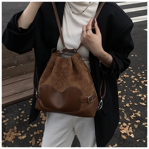 Détail de sac seau avec cordon de serrage et patch en cœur en daim et cuir lisse