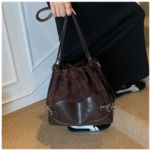 Détail du sac seau marron foncé à cordon avec texture suédée et garnitures métalliques