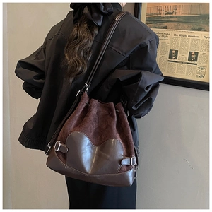 Détail d'un sac seau vintage en cuir marron et daim avec empiècement en cœur