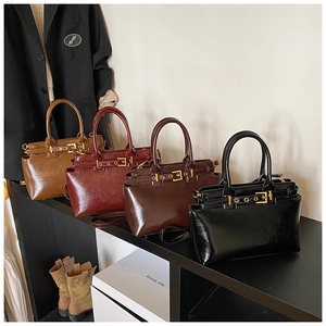 Detail view of vintage handbags in camel, burgundy, brown, and black with glossy finish