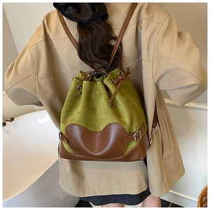 Détails d'un sac à dos en daim vert avec finitions en cuir marron et boucle en métal