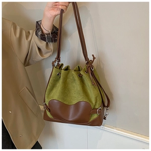 Détail du sac seau en daim olive et cuir marron avec un fond en cuir unique en forme de cœur