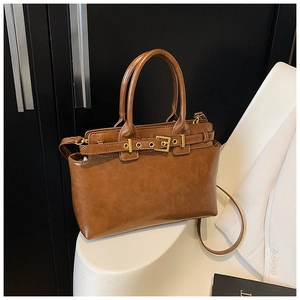 Detail of vintage brown tote bag with decorative buckle and smooth oil wax leather finish