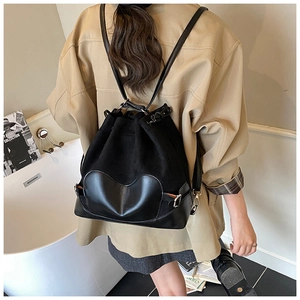 Détail du sac à dos noir à cordon avec empiècement en cuir en forme de cœur sur le fond