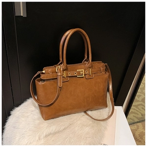 Detailed view of the brown PU leather handbag featuring retro gold buckle and top handle