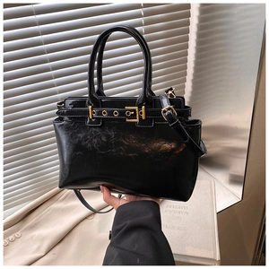 Detail of black vintage tote bag with gold hardware and embossed faux leather finish