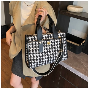 Detail of houndstooth tote bag with metal twist lock and leather trim for women