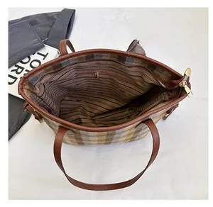 Internal view of plaid tote bag featuring striped lining and spacious zipper pocket