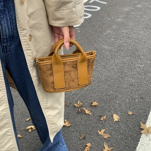 Gros plan du mini sac à main en toile marron camel avec poignées en similicuir