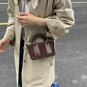 Gros plan d'un mini sac cabas en daim marron avec garniture en cuir pour un style urbain chic