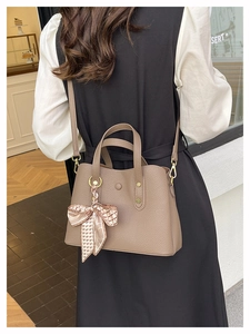 Taupe lychee leather handbag with checkered silk scarf on a model in a cafe setting