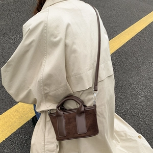Détail d'un sac à main patchwork en toile marron avec garniture argentée sur un modèle