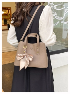 Litchi pattern handbag with pink silk scarf detail shown in a cozy bakery setting