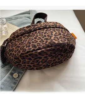 Détail du sac banane à imprimé léopard avec texture velours et étiquette orange