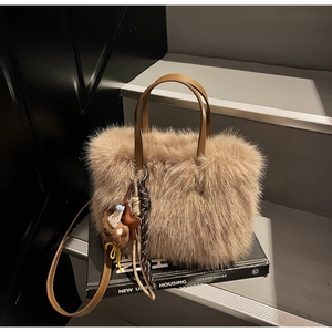 Detailaufnahme der braunen Plüsch-Handtasche mit Ledergriff und Stern-Anhänger