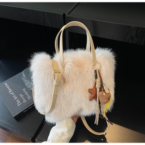 Detail der Plüschtasche mit süßem Bärenanhänger und verstellbarem Lederriemen