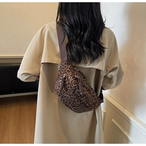Détail du sac bandoulière à motif léopard avec doubles fermetures éclair sur trench-coat