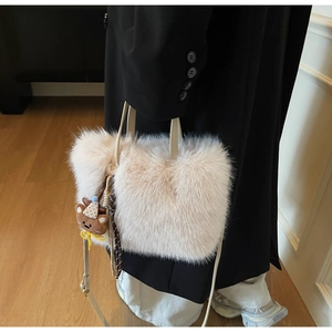 Detail der beigen Plüschtasche mit süßem Bärenanhänger und verstellbarem Lederriemen