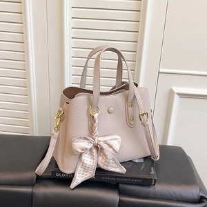 Detail of beige textured leather tote with silk scarf accent and gold hardware