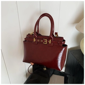 Retro deep red handbag with decorative buckle and golden hardware in a 45-degree view