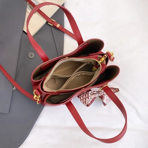 Top view of red litchi leather handbag interior with compartments and silk scarf handle
