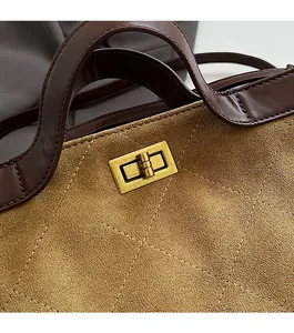 Detail of vintage camel quilted suede bucket bag featuring antique gold twist lock closure