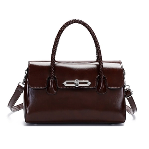 Vintage dark brown leather handbag with woven handle and silver chain lock on white background