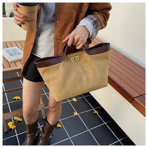 Close-up of suede bucket bag with diamond quilting and retro golden metal twist lock