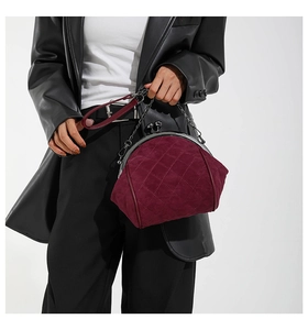 Detail view of burgundy velvet quilted crossbody shell bag with vintage metal clasp and chain
