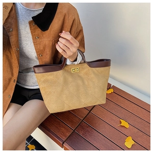 Detail of khaki suede bucket bag with diamond stitching and golden twist-lock closure