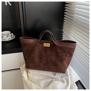 Macro detail of dark brown quilted tote bag featuring golden twist lock and suede texture