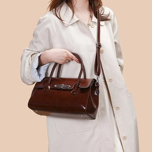 Detailed view of dark brown vintage handbag with woven handle and silver twist lock