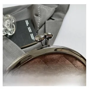Detailed macro view of brown quilted suede coin purse with silver metal frame and clasp