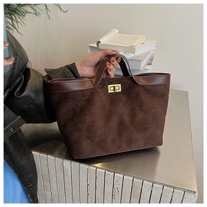 Detail of dark brown quilted suede bucket bag with gold square twist lock and smooth leather trim