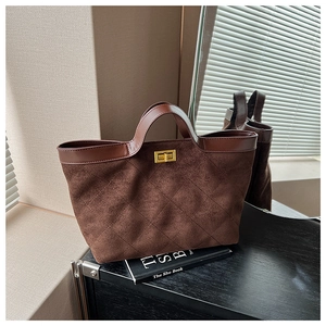 Detailed close-up of dark brown suede bucket bag with diamond stitching and gold turn-lock