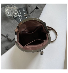 Detail shot of vintage shell bag interior with zipper pocket and metal clasp closure