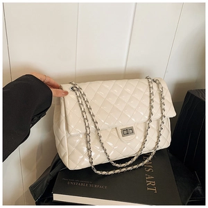 Detailed close-up of quilted pattern leather bag with silver chain strap and metal lock