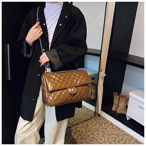 Brown quilted patent leather shoulder bag with silver chain strap shown on model