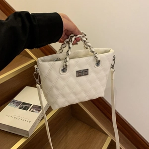 Detailed view of white quilted faux leather handbag with silver chain and metal lock