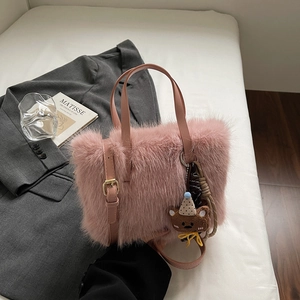 Rosa Plüsch-Umhängetasche mit Bären-Anhänger auf stilvollem grauen Blazer-Hintergrund