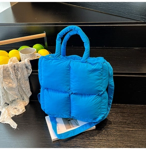Détail du sac matelassé bleu vif en nylon avec sa large bandoulière assortie