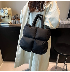 Gros plan du sac cabas matelassé noir avec coutures carrées et poignée rembourrée