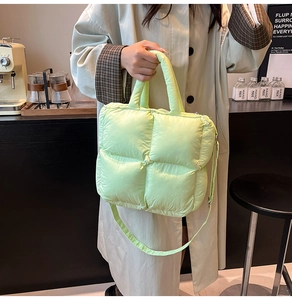 Détail d'un sac à main matelassé vert fluo avec bandoulière dans un décor de café moderne
