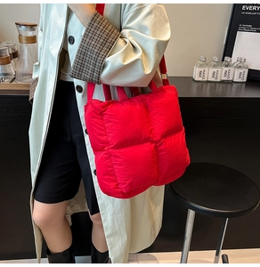 Détail d'un cabas matelassé rouge avec rembourrage carré et bandoulière pratique