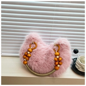 Close-up of pink faux fur handbag with stylish wooden bead handle and metal ring